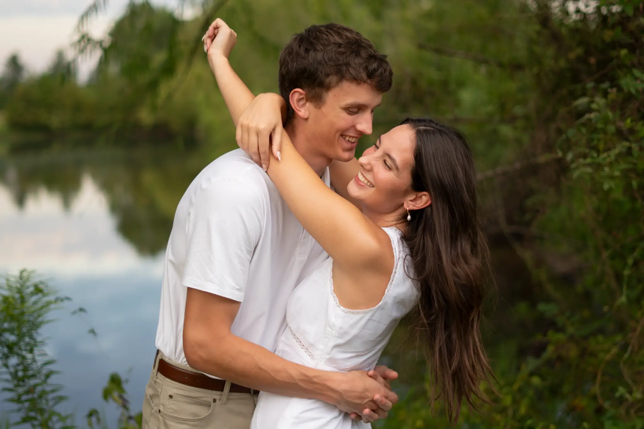 The two of them leaning into each other, laughing, with the lake behind them